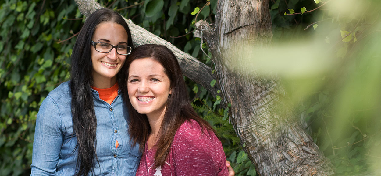 women by tree smiling photo