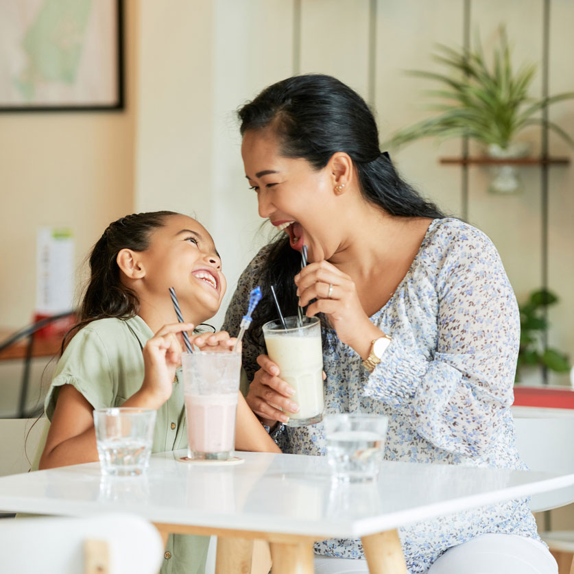 woman and girl drinking milkshakes